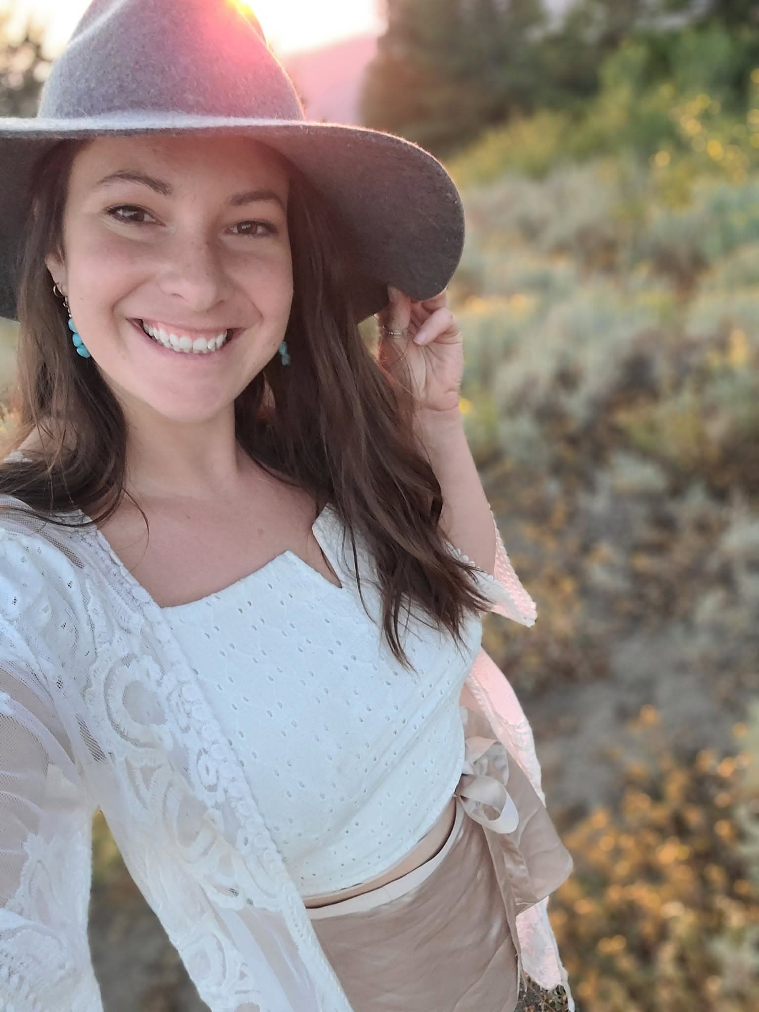 Kelsey, the founder of AfterDoula, smiling in evening light.